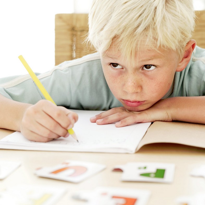 Boy looking up from doing his homework