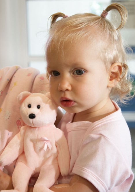 Toddler girl holding her toy bear