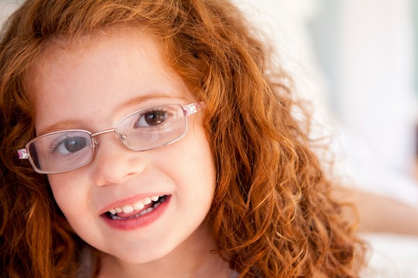 Girl with curly red hair and wearing glasses