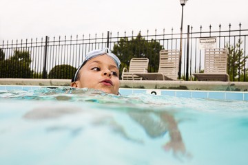 Boy in the pool with goggles on his head