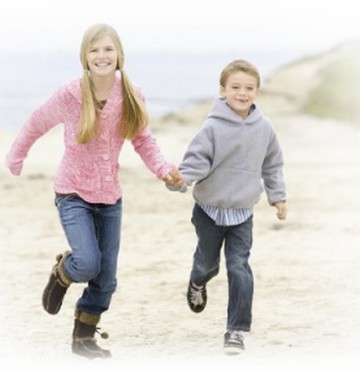 Sister and brother running on the beach