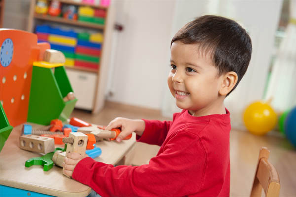 Smiling boy playing with toys in the playroom