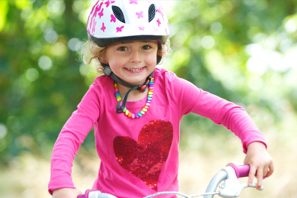 Young girl on a bicycle wearing a helmet