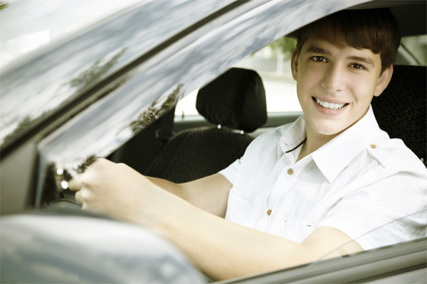 Teenage boy at the steering wheel of a car