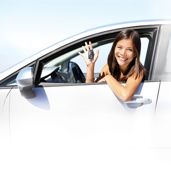 Smiling teen girl in driver's seat holding car keys