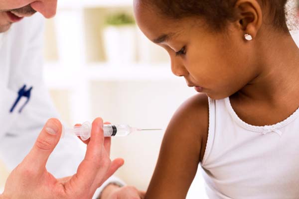 Young girl getting a vaccination shot from a pediatrician