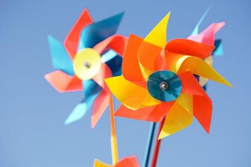 Colorful whirligigs against a blue sky