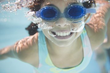 Girl with blue goggles in the water