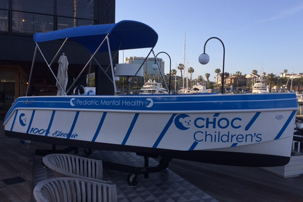 Boat in harbor with CHOC Children's brand