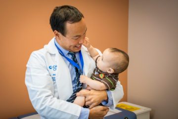 Pediatric surgeon holding child