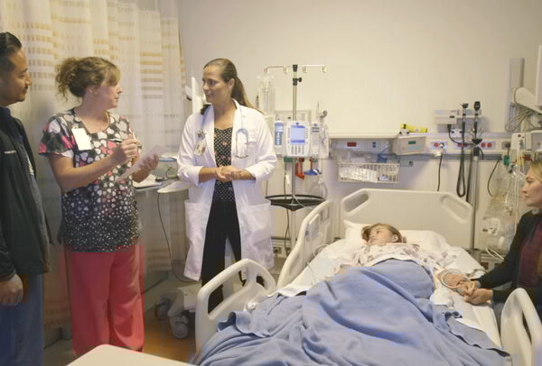 clinical team caring for child in hospital bed