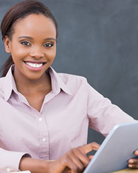 teacher in classroom holding tablet