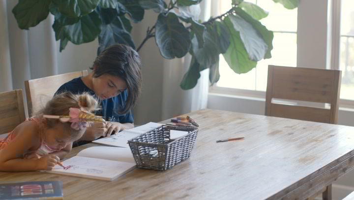 boy and girl at table using pens and colors
