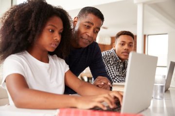 young girl with dad and brother using computer