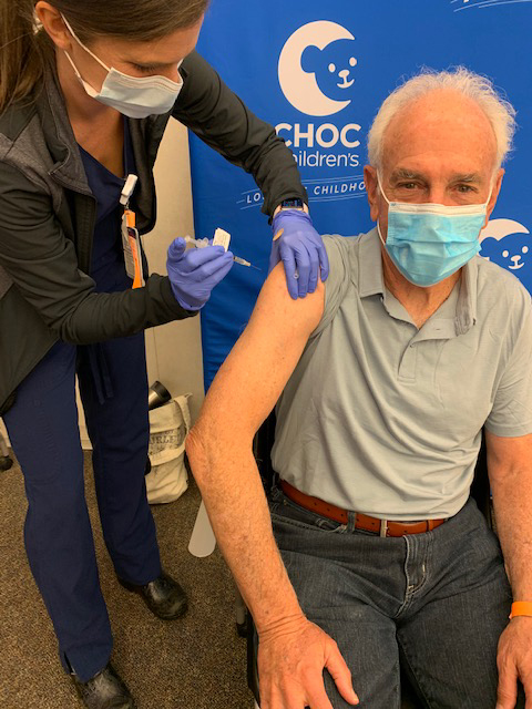 Older man receiving a COVID-19 vaccination
