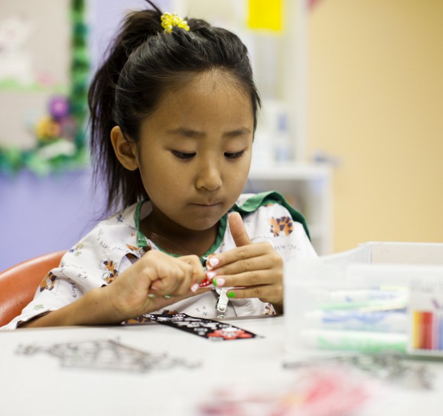 child doing crafts with CHOC art therapy 