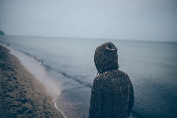 depressed teen at a cloudy beach