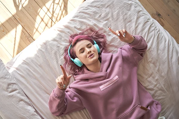 teen girl with pink hair relaxing listening to music