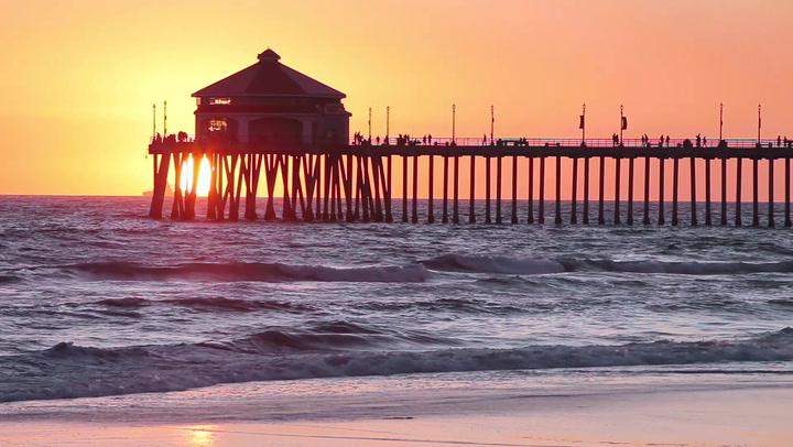image of a pier over the ocean at sunset