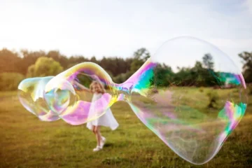 Little girl making a big soap bubble