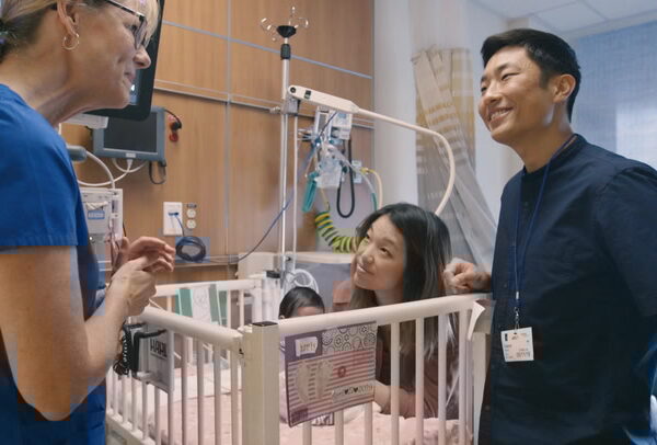 Parents in the NICU with their child and nurse