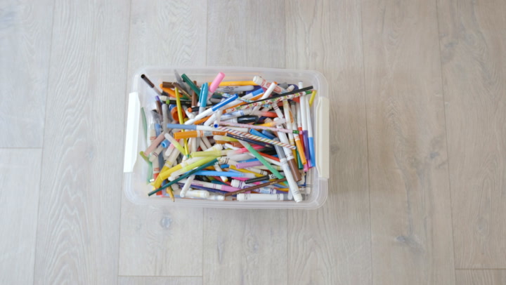 a box of pens and crayons