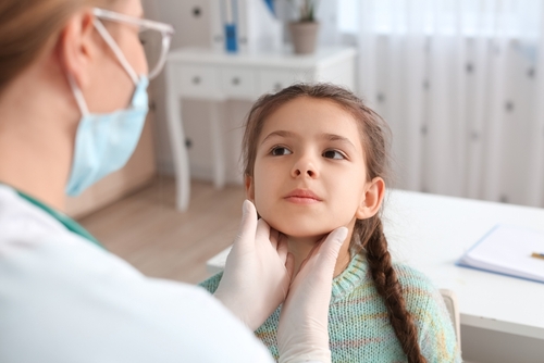 Doctor,Examining,Little,Girl's,Neck,In,Clinic