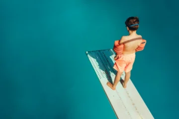 boy standing apprehensively on a diving board