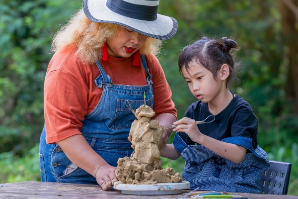 little girl in the zone working with pottery clay