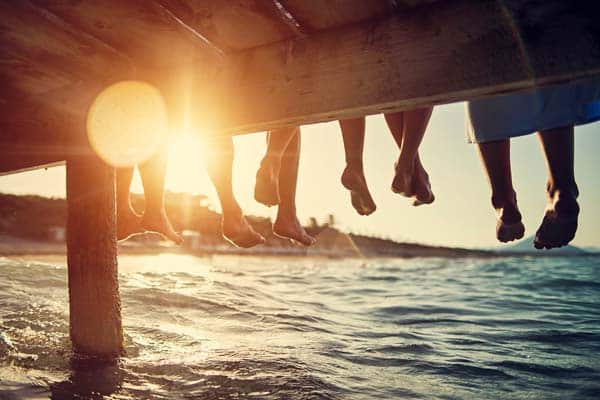Feet hanging off of pier
