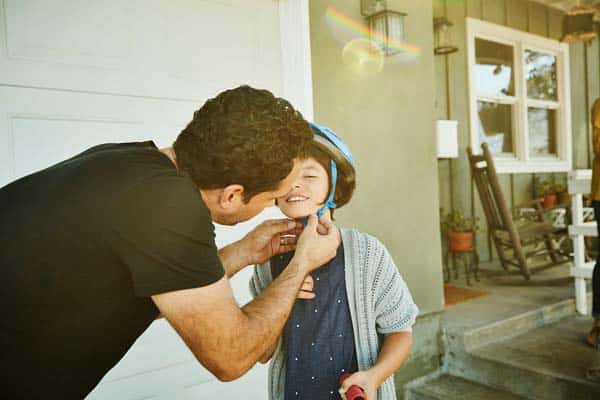 dad putting child's helmet on