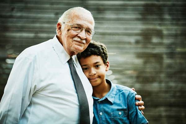 Grandpa and child standing together and smiling