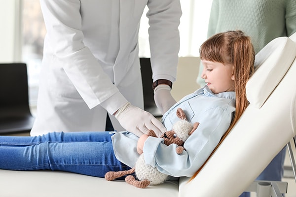 Girl getting stomach checked at doctor's office