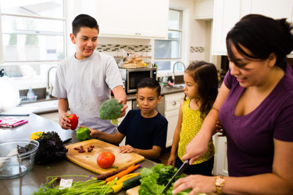 family cooking healthy food together in a kitchen