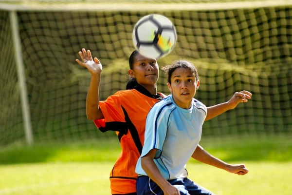 two teens playing soccer