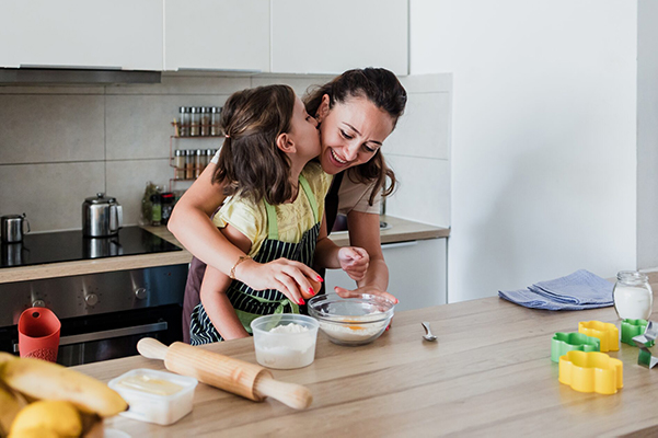 Parent and daughter cooking together