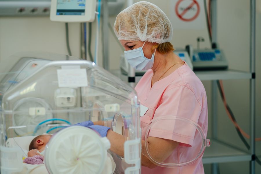 Doctor checks on baby in a incubator