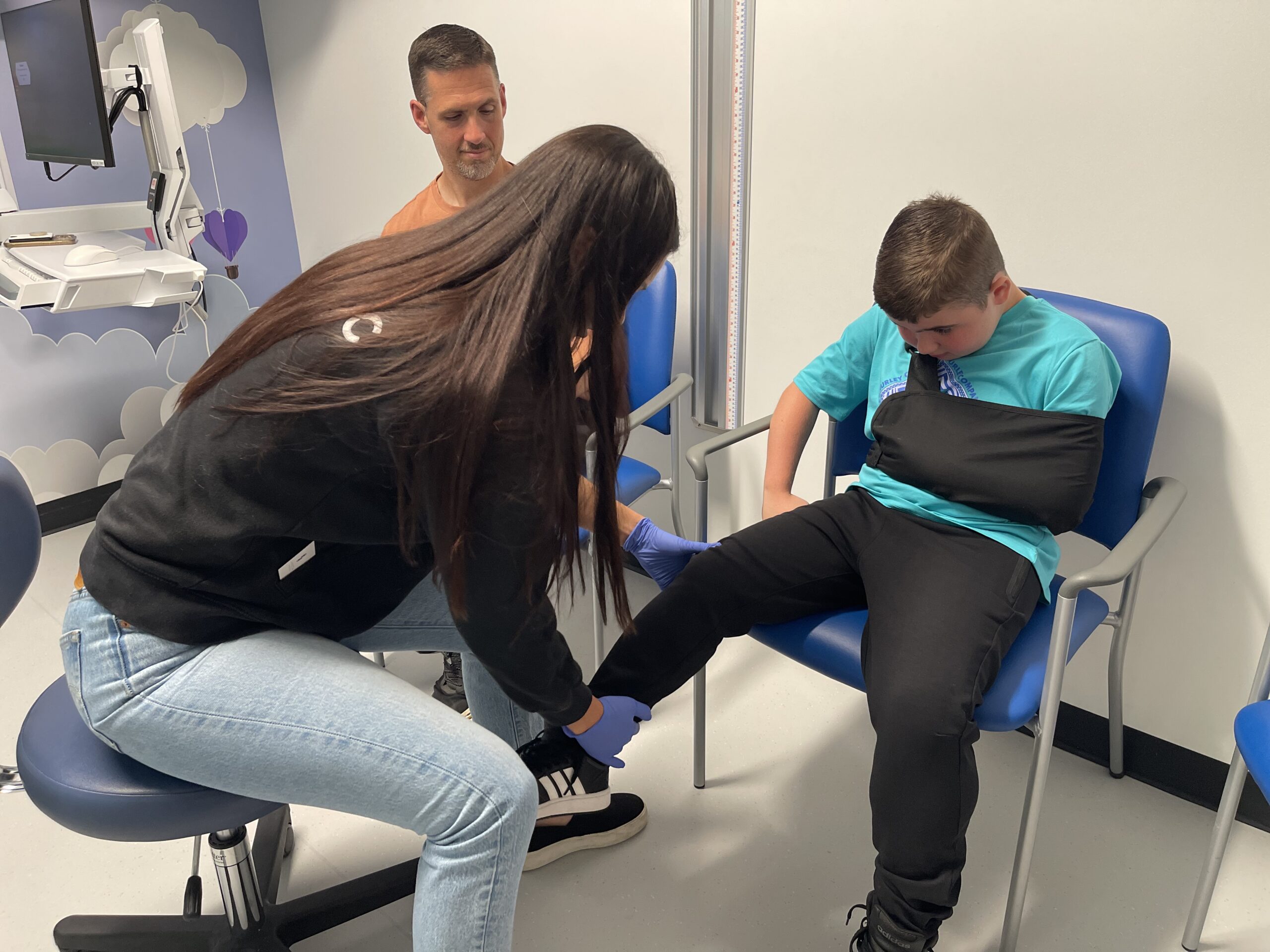 A young patient is examined by a welcoming care team member from CHOC's muscular dystrophy program in a family-friendly environment. The patient is