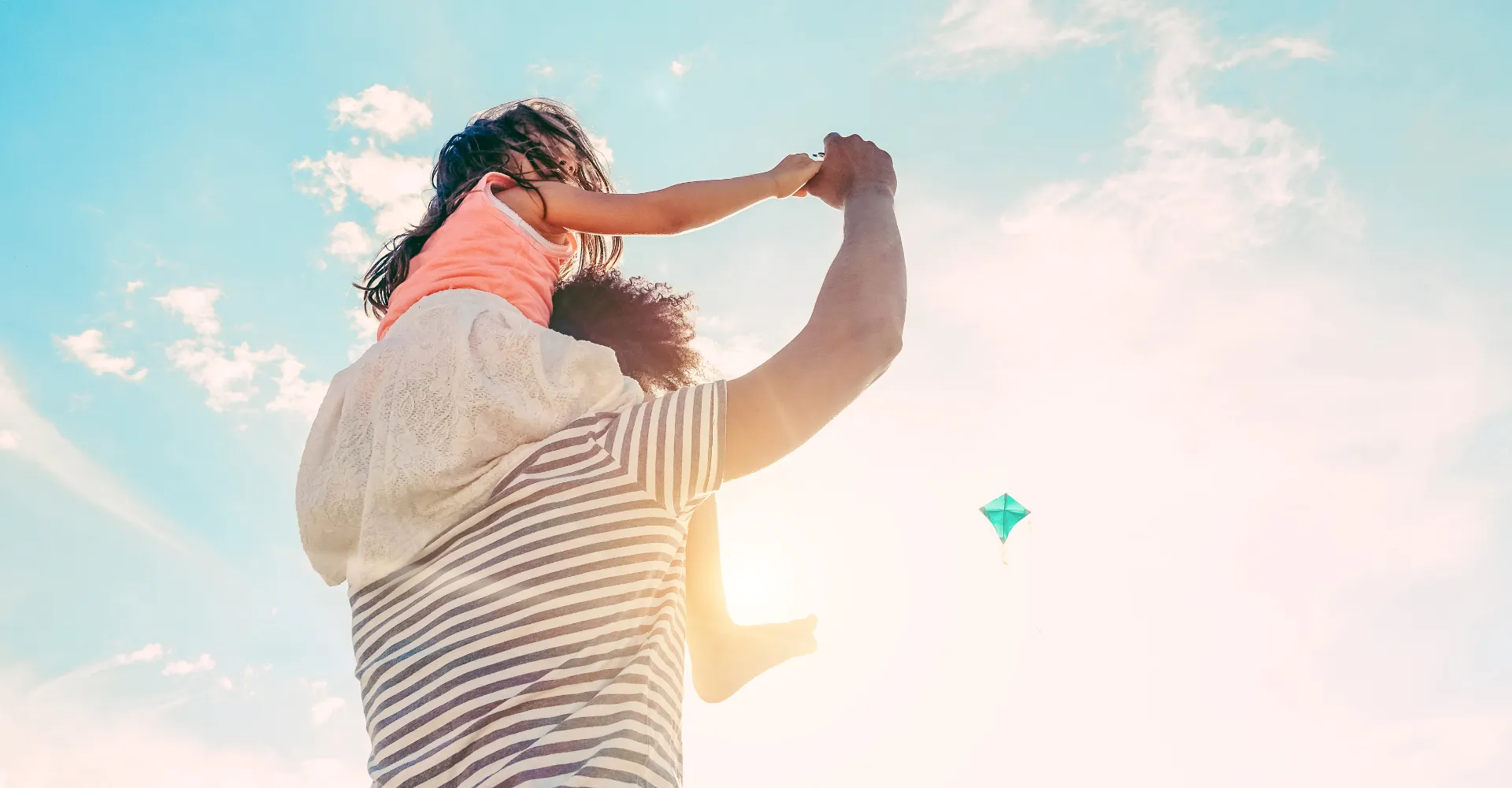father holding daughter up on shoulders