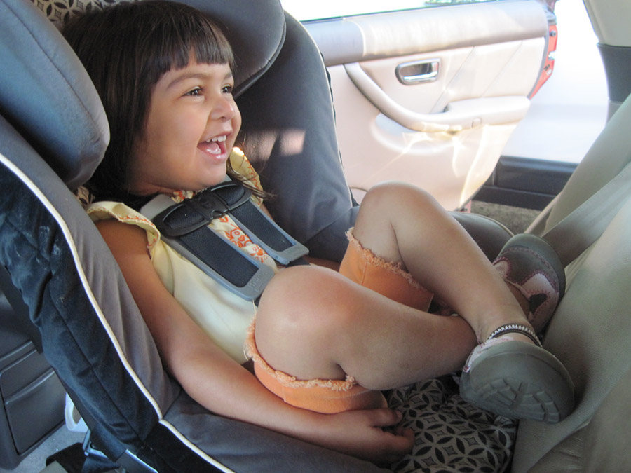 young girl sitting in secured car seat