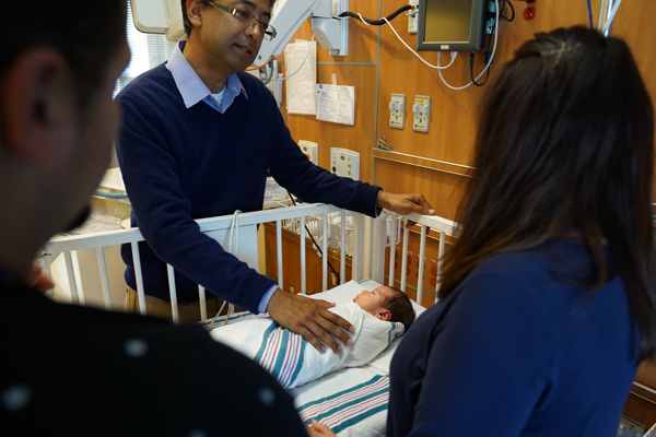 doctor talking to parents with baby in NICU